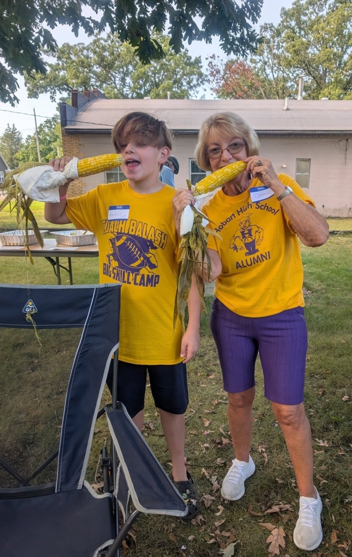 Aaron Stillwell (2033) and Debbie Vega (1971) eat corn cooked by Harry Beals (1970)